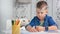 Confident talented cute little boy drawing picture using colorful pencil medium close-up