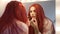 Confident transgender man in red wig applying red lipstick reflecting in mirror. Portrait of proud Caucasian LGBT person