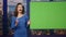 Confident tv presenter hosting newscast on green screen at studio close up.