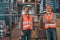 confident warehouse workers in vests looking at camera