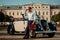 Confident wealthy young man with briefcase near classic convertible