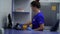 Confident woman in blue uniform and rubber gloves putting the rack for test tubes in the special fridge. Conducting