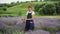 Confident woman making bouquet of lavender looking at camera and talking. Portrait of beautiful Caucasian gardener