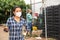 Confident woman in mask posing near greenhouse