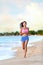 Confident Woman Runner Jogging On Beach Shore