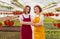 Confident women in large greenhouse looking at camera