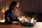 Confident writer working on a typewriter, seated at a table, over blurred interior. Copy space.