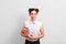 Confident young beautiful caucasian female student holding a bunch of notebooks and smiling against grey background. investment in