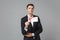 Confident young business man in classic black suit shirt posing isolated on grey wall background studio portrait