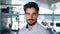 Confident young business man looking at camera in office, headshot portrait.