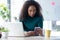 Confident young business woman sending messages with mobile phone sitting in the office