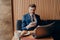 Confident young businessman in formal clothes enjoying coffee and working remotely in cafe