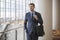 Confident Young Businessman at Hotel by Escalator business trip