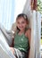 Confident young girl sitting in hammock on vacation