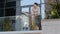 Confident young hispanic business man standing at railing modern skyscraper office building looking away holding phone