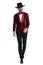 Confident young man in red velvet tuxedo wearing hat and walking