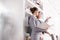 Confident young saleswoman gesturing to female client while holding document in apartment