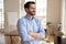 Confident young smiling businessman looking at window.