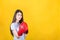 Confident young woman with red boxing gloves stands in fighting stance. Portrait of determined girl ready for battle isolated on