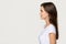 Confident young woman standing in profile looking forward at copyspace