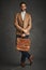 Confidently charming. Studio shot of a handsome young man posing against a gray background.