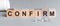 Confirm is a word written in black letters on wooden cubes