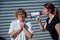 The conflict of generations. An angry middle-aged woman yells at an elderly mother through a megaphone. An adult