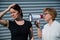 The conflict of generations. An old woman yells into a megaphone at her middle-aged daughter against gray background