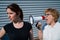 The conflict of generations. An old woman yells into a megaphone at her middle-aged daughter against gray background