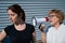 The conflict of generations. An old woman yells into a megaphone at her middle-aged daughter against gray background