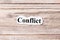 Conflict of the word on paper. concept. Words of Conflict on a wooden background