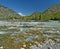 The confluence of mountain stream with clear water in the muddy waters of the river Katun, Altai Mountains, Siberia, Russia