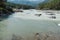 The confluence of two rivers. Two different rivers are connected into one. The river is of different colors. Mountain river of