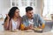 Confused Arab Couple Suffering Problems With Laptop While Eating Breakfast In Kitchen