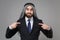 Confused arabian muslim businessman in keffiyeh kafiya ring igal agal classic black suit shirt isolated on gray