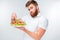 Confused bearded man holding plate with salad