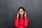 Confused brunette woman in red blouse having headache