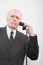 A confused businessman using a telephone