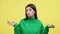 Confused Caucasian Woman spreading arms on Yellow Background