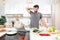 Confused handsome man cooking vegetable salad in kitchen