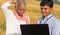 Confused Indian farmer Scratching his head while banker or corporate government officer discussing on laptop about crop yield,