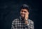 Confused Indian young man touching his head. Studio photo against a dark textured wall