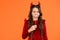 Confused kid with long hair wear devil horns hold funny party accessory for autumn halloween holiday celebration, happy