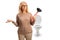 Confused mature woman holding a toilet plunger in front of a toilet seat