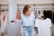 Confused pensive young woman choosing between two t-shirts