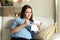 Confused pregnant woman reading a leaflet before take a pill