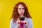 Confused redhaired ginger curly woman colding plastic creditcard and looking upsad .rejection concept