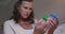 Confused senior caucasian woman holding and looking at two bottles of tablets