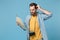 Confused traveler tourist man in summer yellow clothes with photo camera isolated on blue background. Passenger