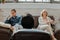 Confused and upset adult couple sitting on different sides of couch